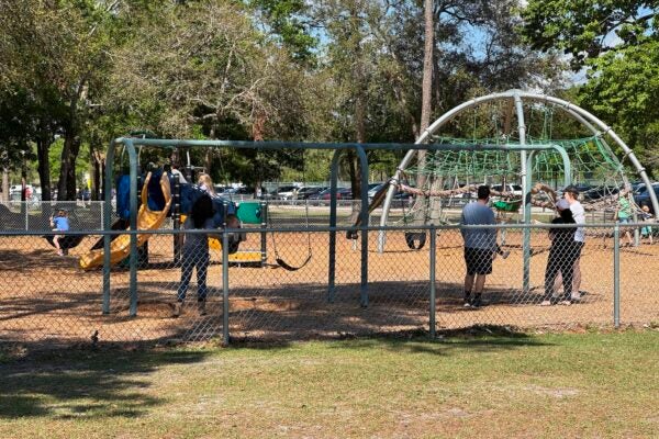 Parents and children playing at a playground.