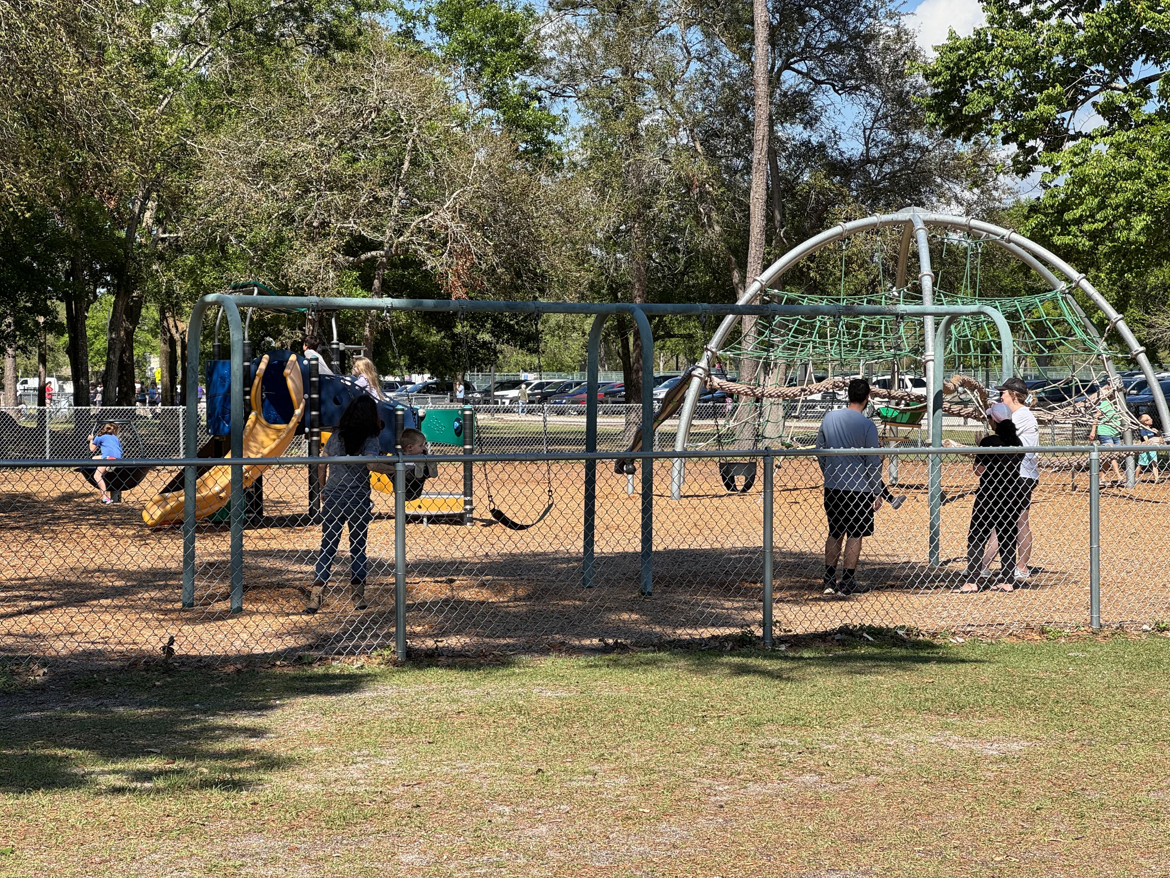 Parents and children playing at a playground.