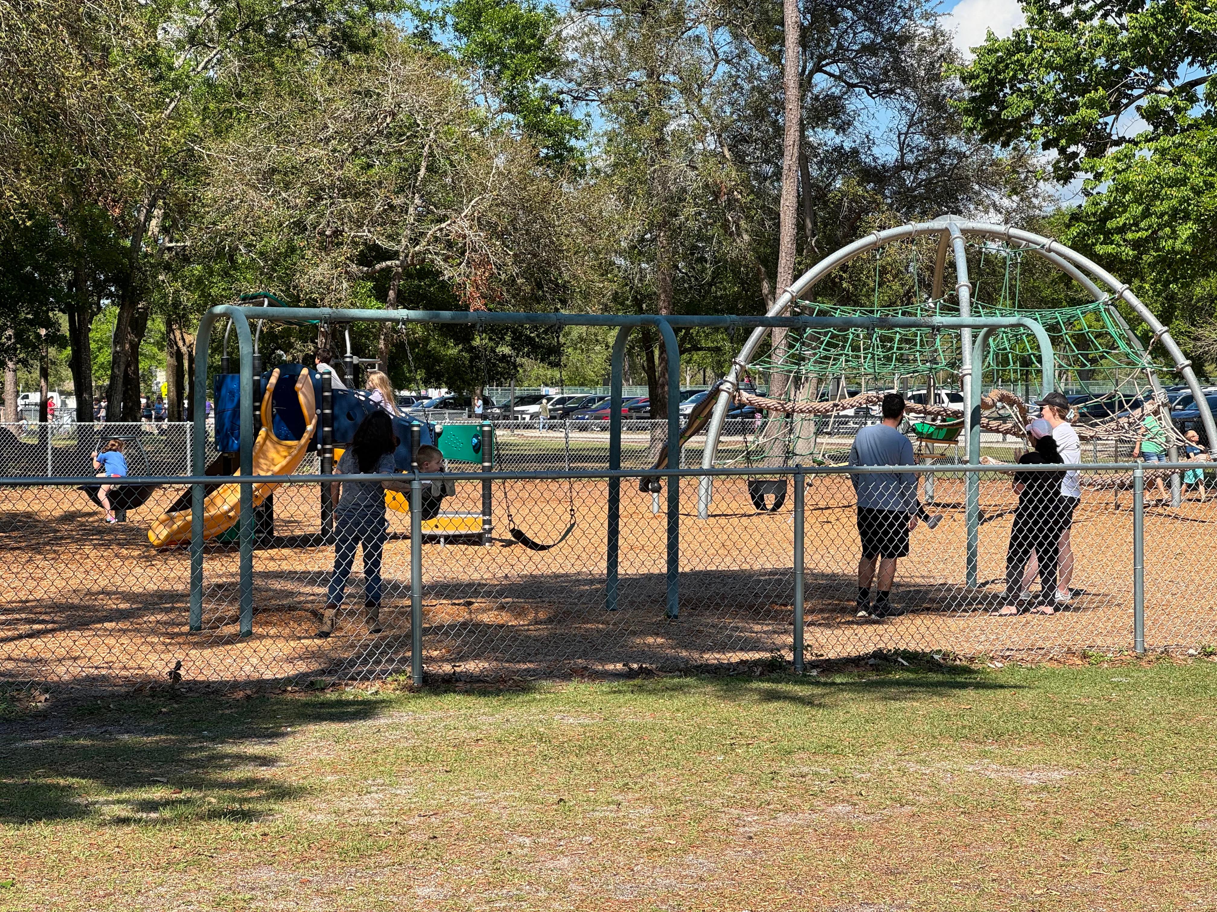 Parents and children playing at a playground.