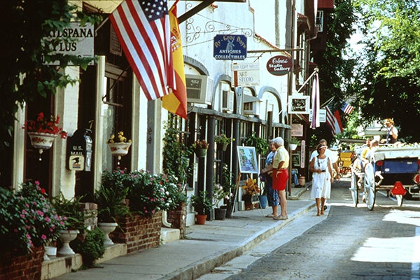 Tourists walking down street with shops