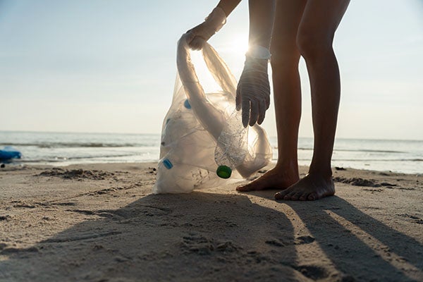 Woman picking up trash on the beach