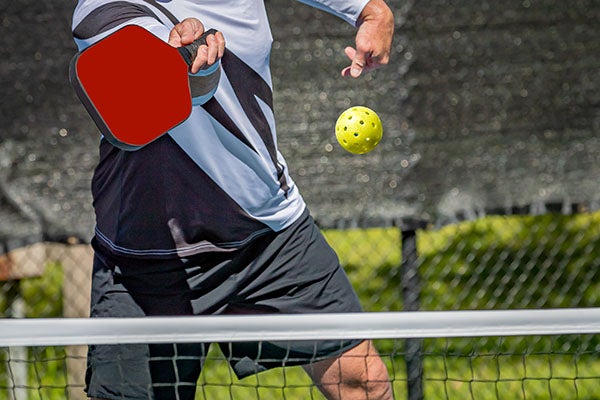 Male pickleball player about to hit a volley shot