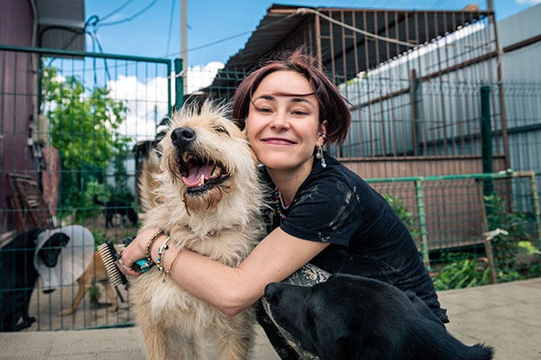 dog at shelter with volunteer