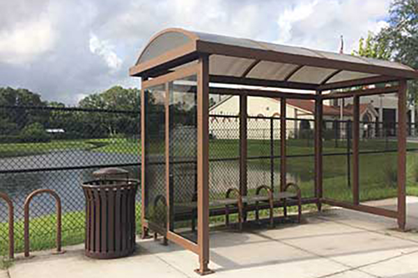Bus shelter with a pond behind it.