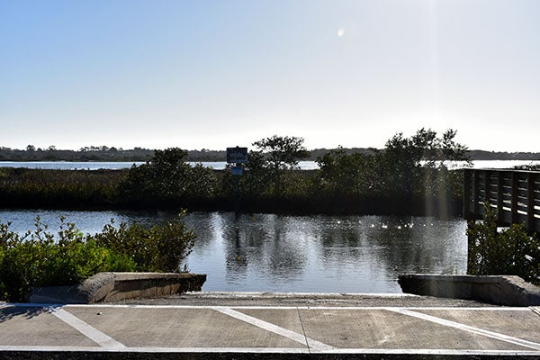 A boat ramp at body of water and pier