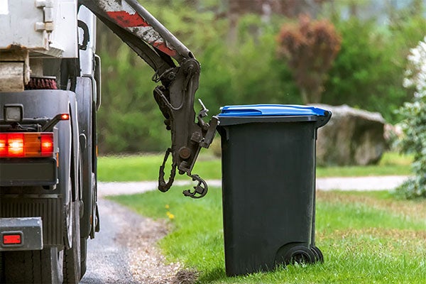 garbage can being taken by garbage truck