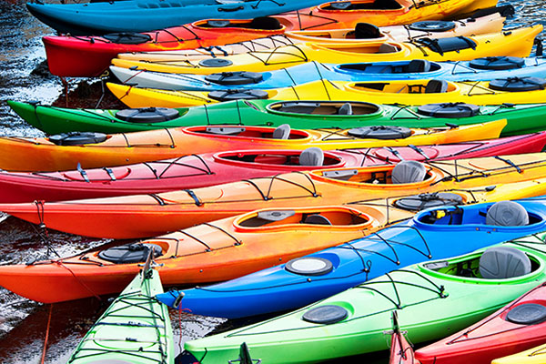 lots of colorful kayaks on the shore