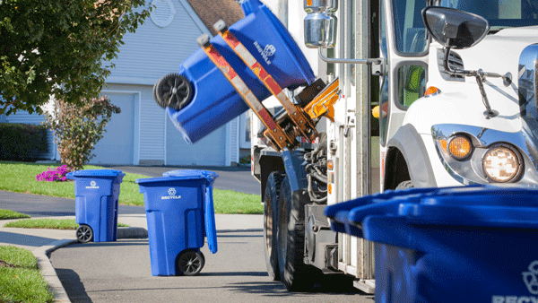 Trash can being emptied into dump truck