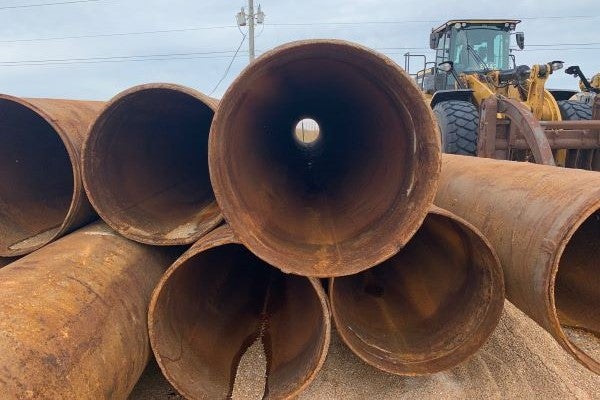 Dredge pipe is stacked for storage.