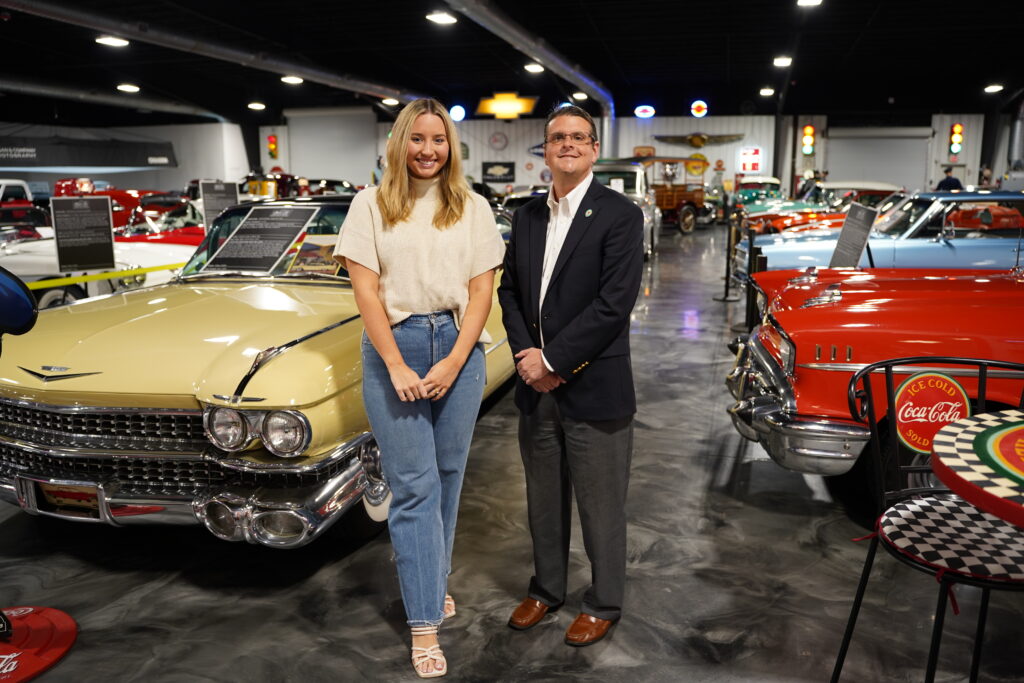 Commissioner Alaimo and Classic Car Museum representative standing next to car in museum