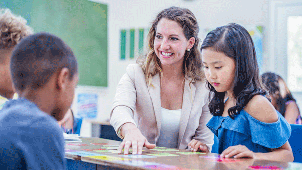 a woman teach children in the classroom