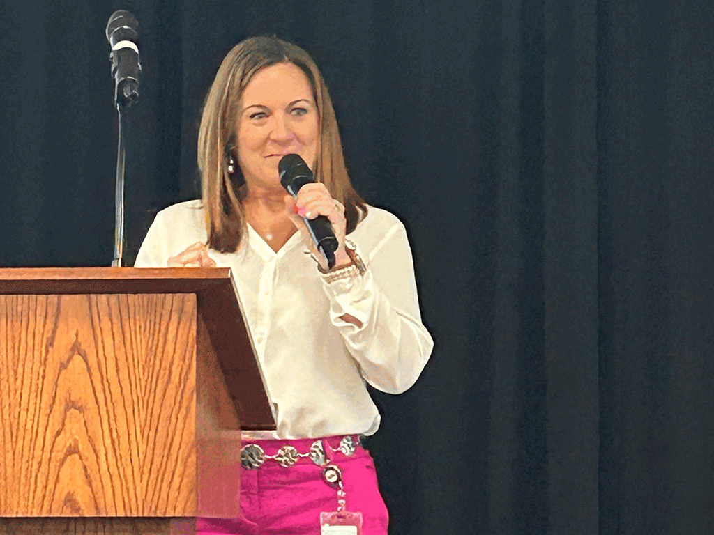 Sara Maxfield speaks into a microphone at a podium for the State of the Region address.