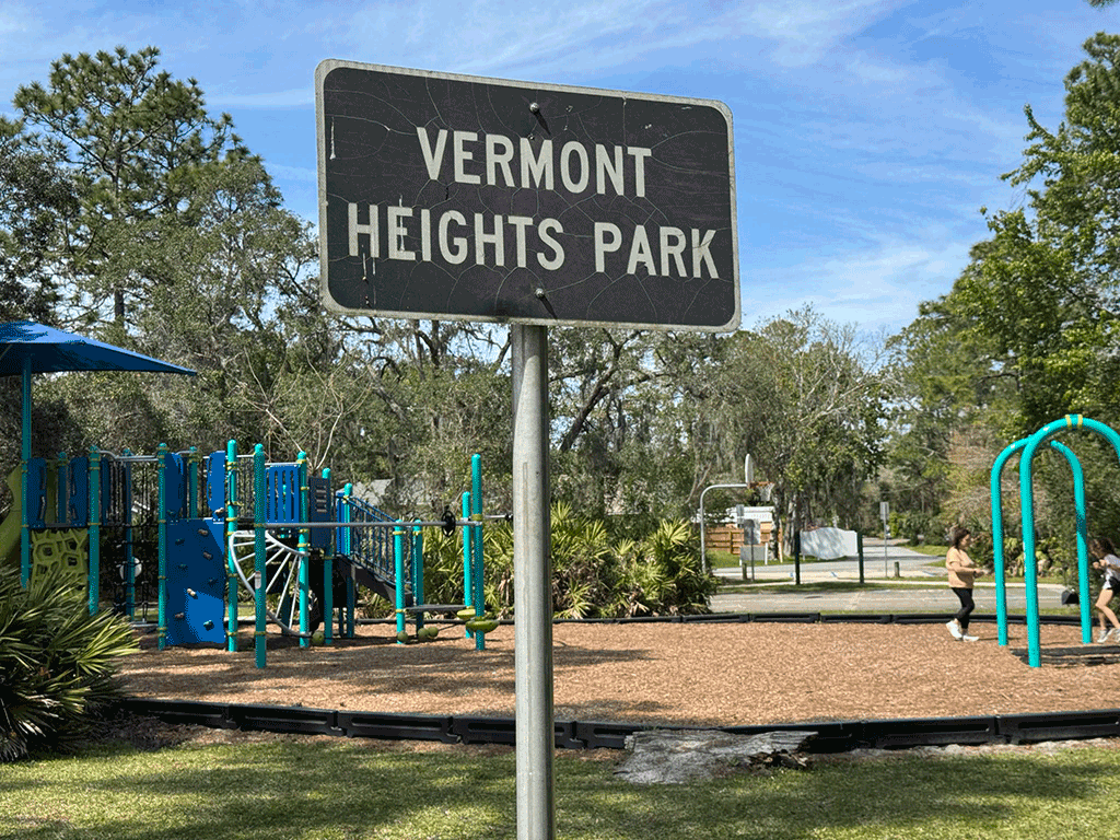 A small sign in front of a playground that reads ‘Vermont Heights Park.