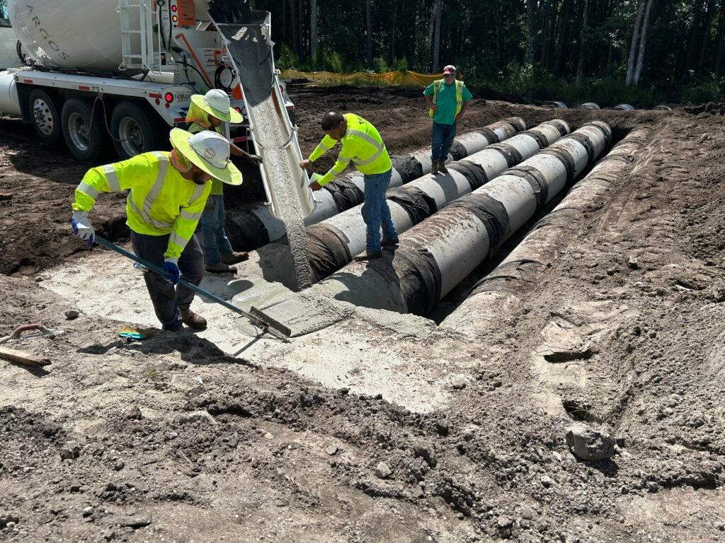Photo of crews working on pipes to go underneath the CR 210 roadway improvements.