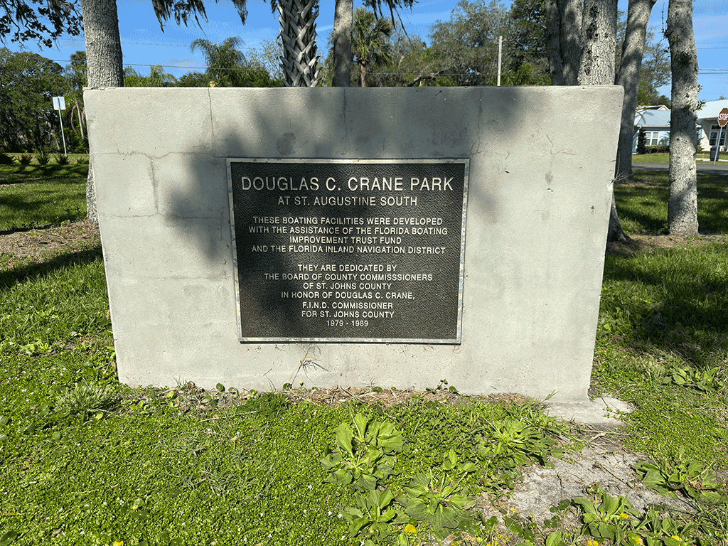 A large rock bearing a plaque for Douglas Crane Park at St. Augustine South.