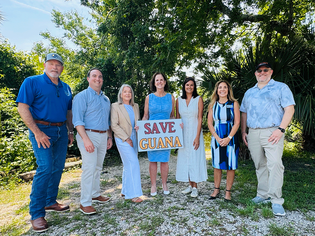 Commissioners Arnold, Whitehurst, Murphy, and Taylor stand with others holding a "Save Guana" sign.