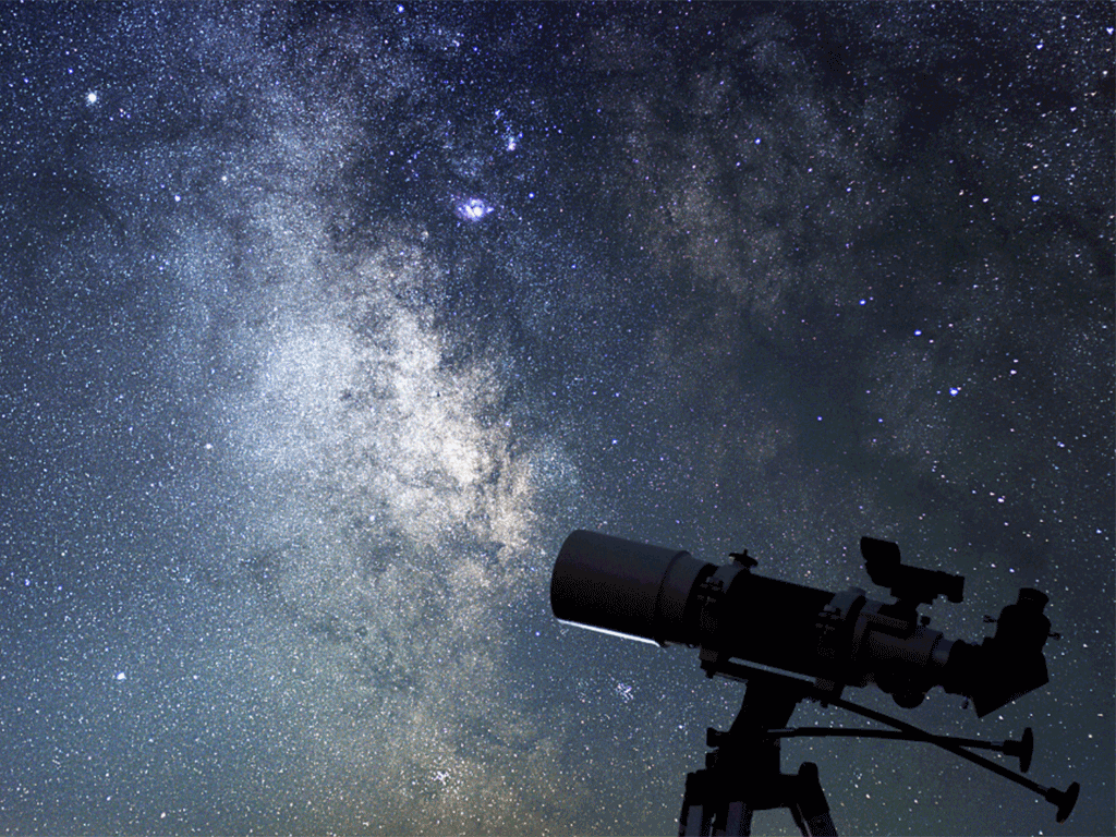 A telescope pointed upward at a starry night sky.