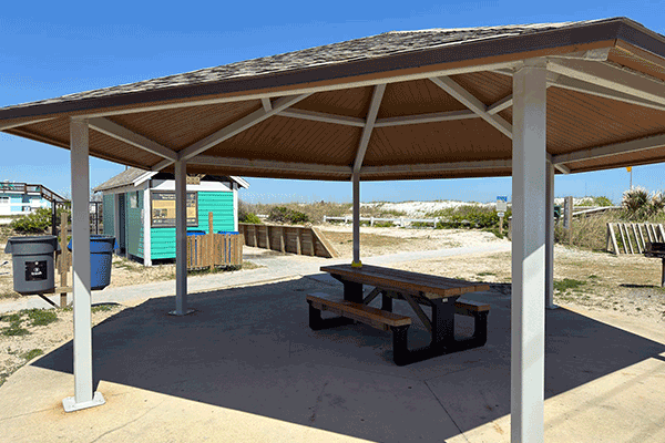 A small beach pavilion over a picnic table.