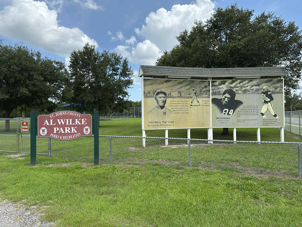 A sign for Al Wilke Park, next to a billboard honoring baseball player John Henry ‘Pop’ Loyd and football player Derrick Ramsey, notable residents of Hastings, Florida