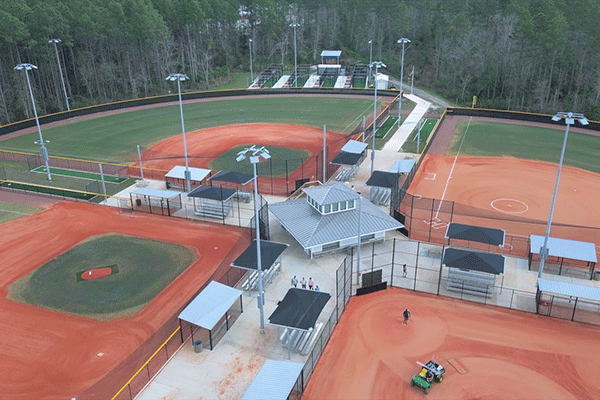 An aerial view of a park with two softball fields, two baseball fields, and batting cages.