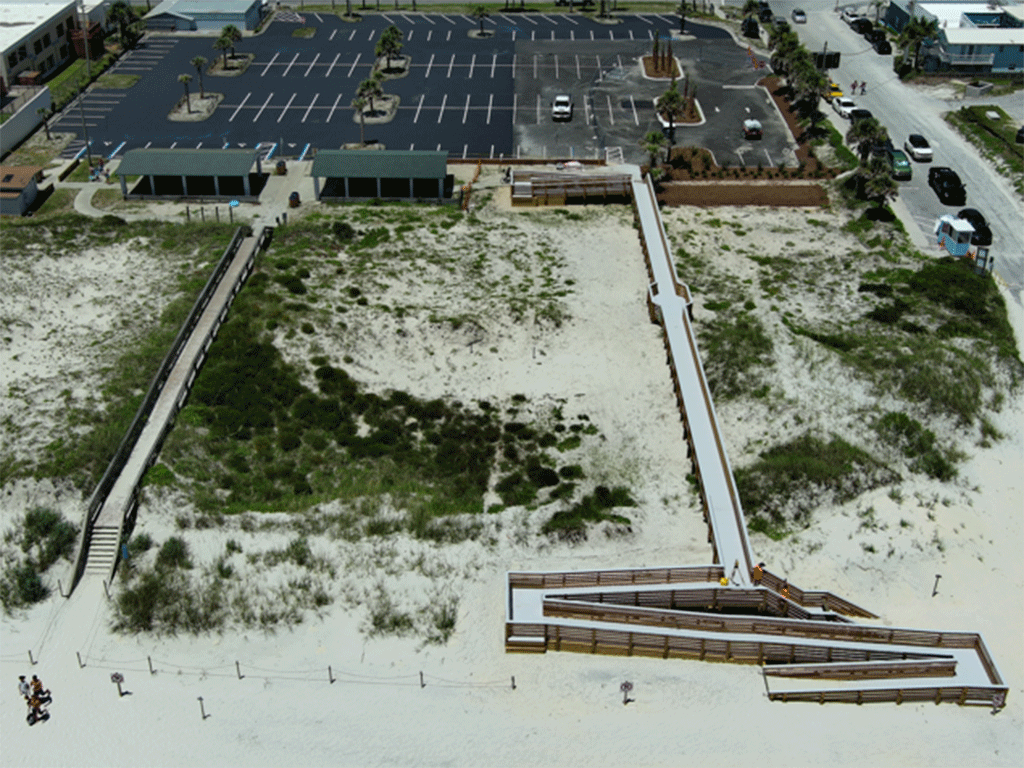 An aerial view of an ADA beach access ramp leading to the sand from a newly expanded parking lot.