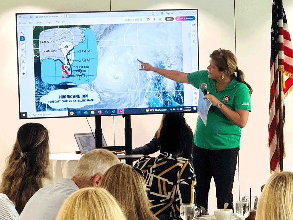 Deputy Director of Emergency Management Kelly Wilson presents in front of a screen depicting Hurricane Ian's path across Florida,
