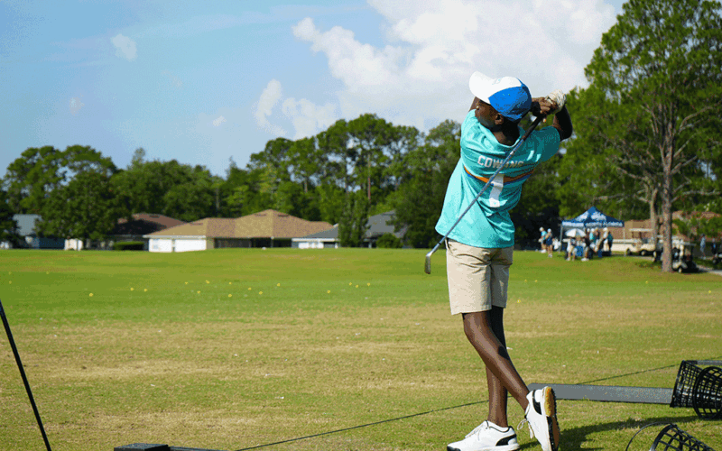 A golfer mid-swing out on the green.