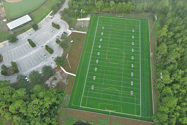 An aerial image of a football field and parking lot.