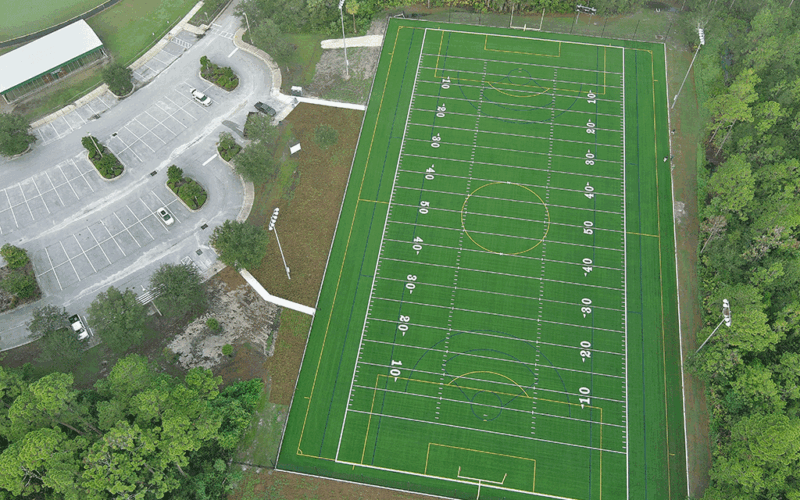 An aerial image of a football field and parking lot.