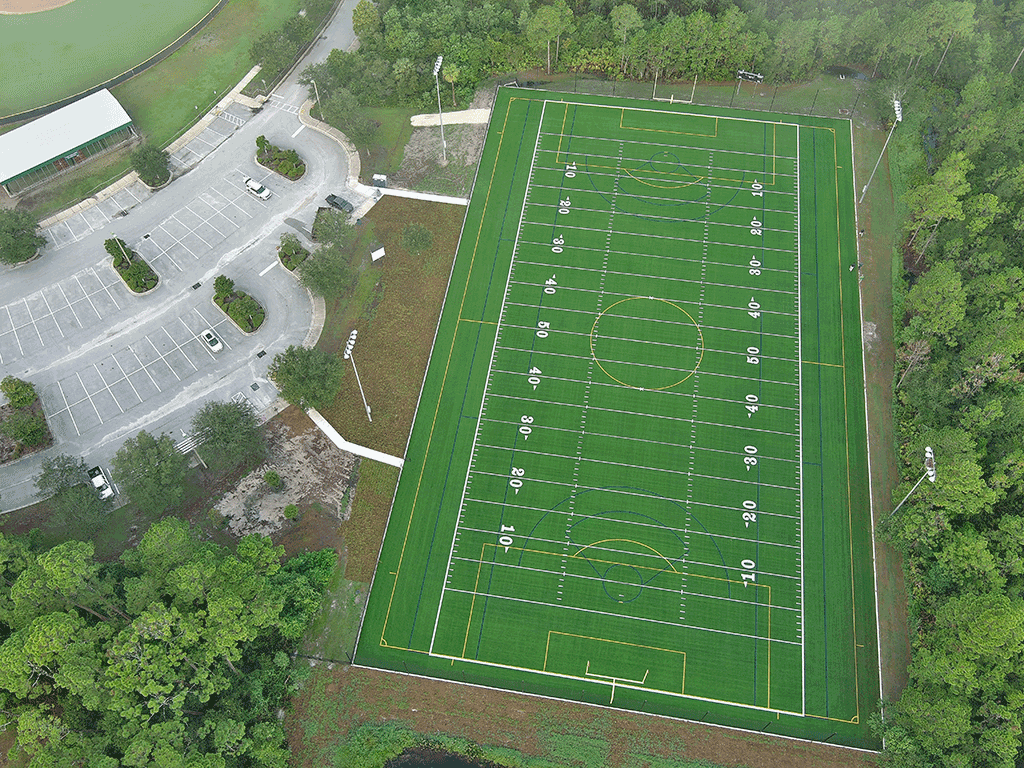 An aerial image of a football field and parking lot.