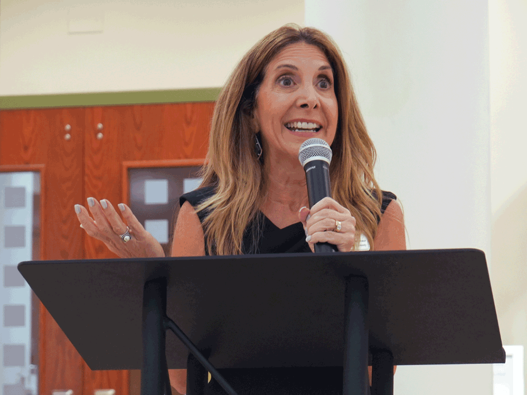 Commissioner Taylor speaks into a microphone at a podium.