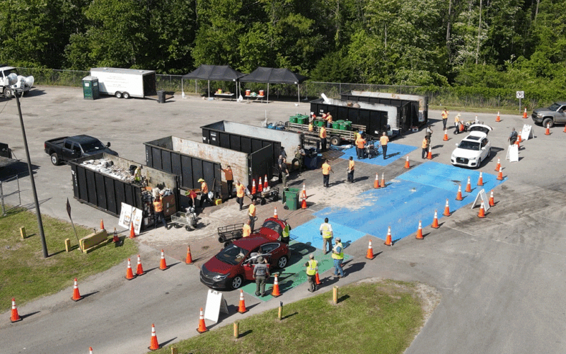 aerial view of people driving through a hazardous waste collection event with recycle containers holding trash