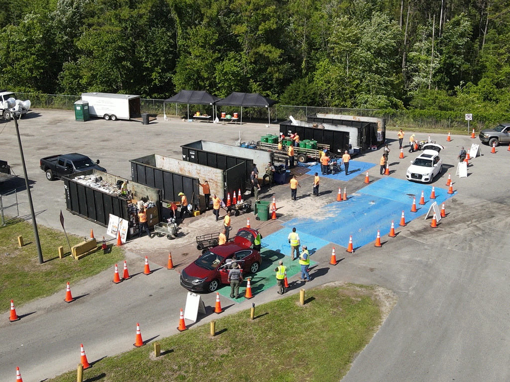 aerial view of people driving through a hazardous waste collection event with recycle containers holding trash