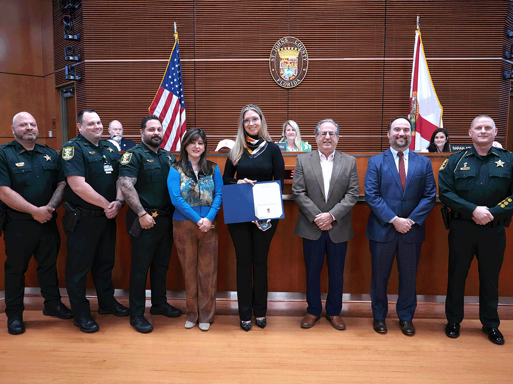 Commissioner Whitehurst stands with Jorge Bertran and others accepting the proclamation.