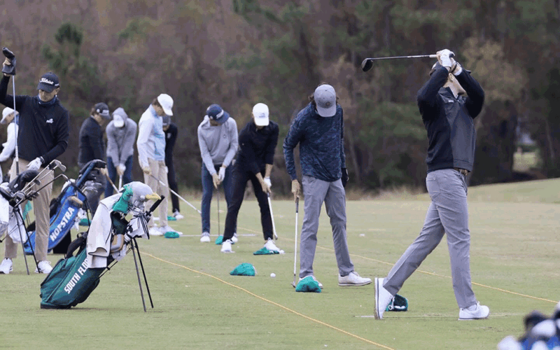 Men playing golf in a row.