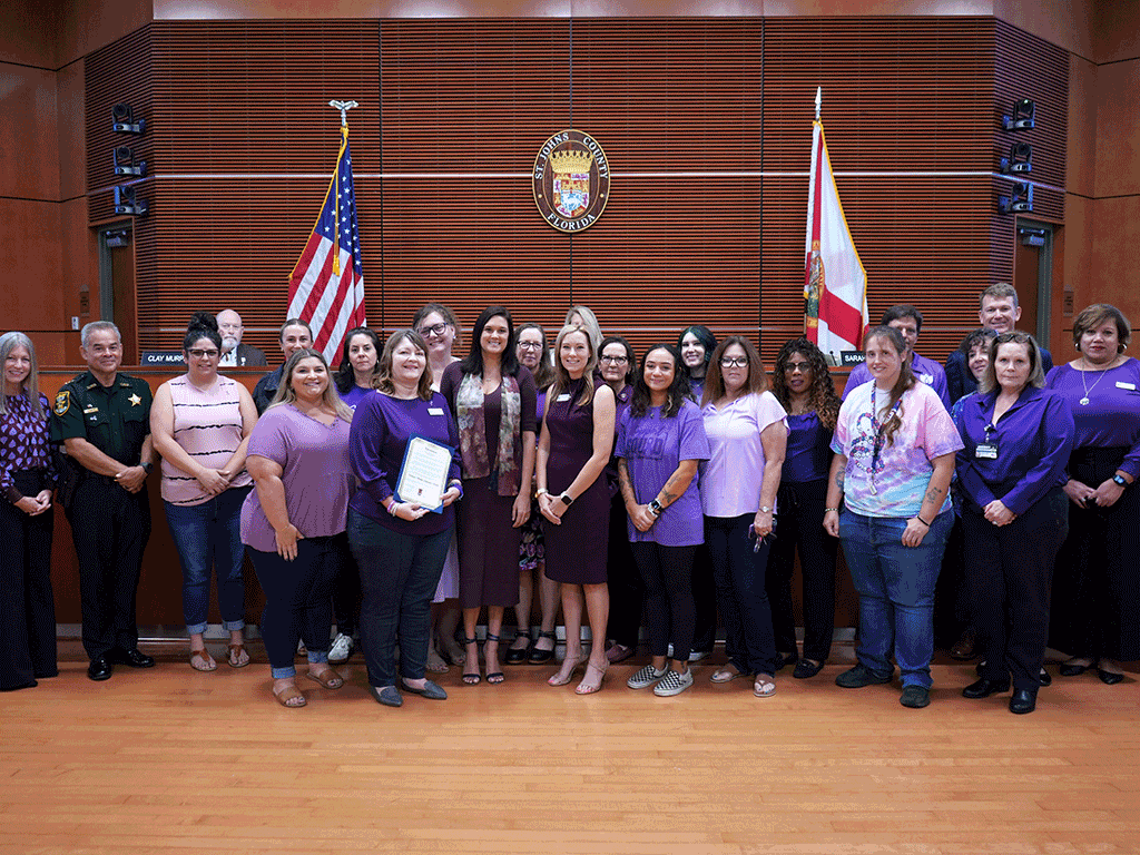 Commissioner Arnold stands with Kelly Franklin and others.