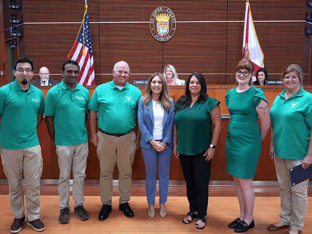 Commissioner Ann Taylor stands with Courtney Toelle, Kellie Anderson, Tim Wilson, and other 4-H representatives.