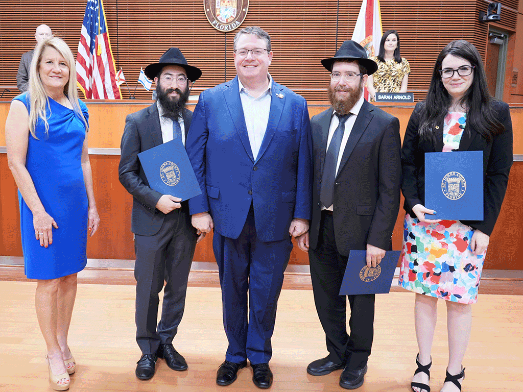 Commissioner Joseph and others stand with the proclamation for Isreal Friendship Day