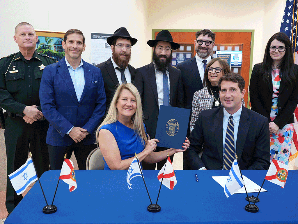 Commissioner Joseph and others sit with the proclamation for Isreal Friendship Day
