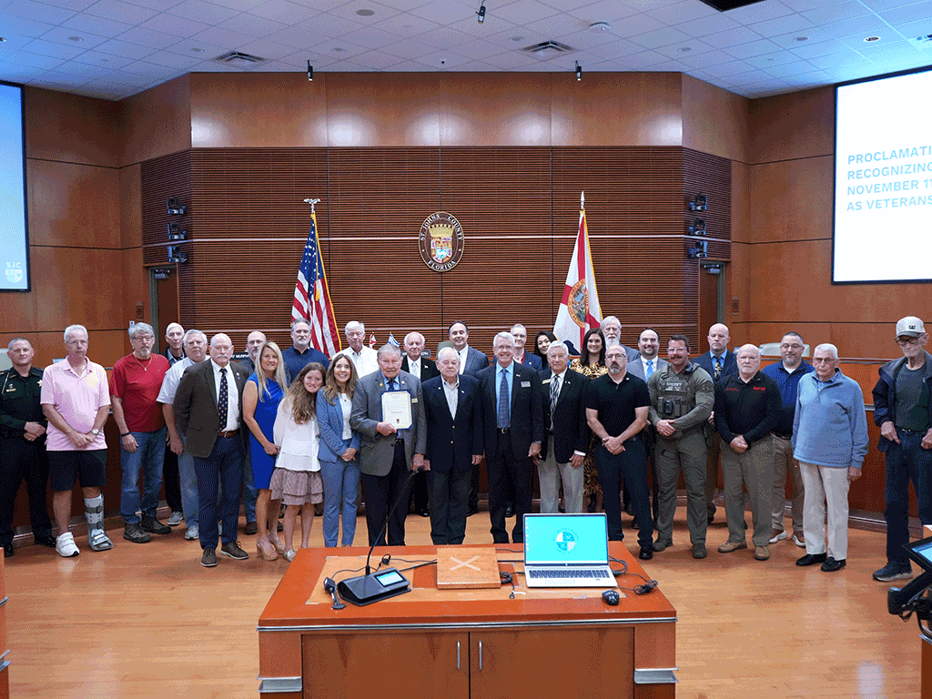 A group of people stand with the proclamation for Veterans Day 2025