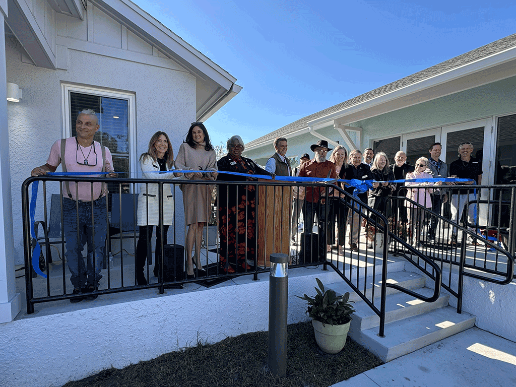 Commissioner Arnold and Commissioner Taylor pose with others in front of the Home Again houses