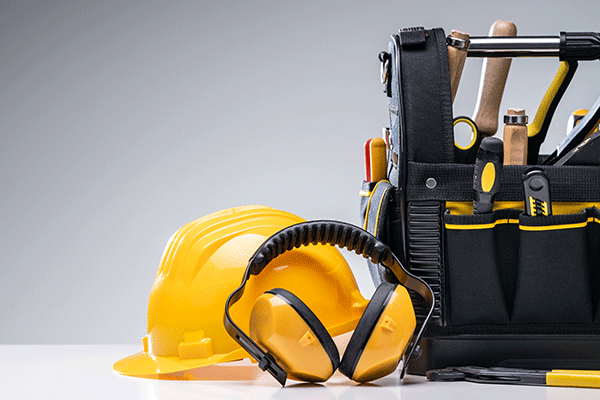yellow hard hat, ear protectors, and a toolbag with miscellaneous tools