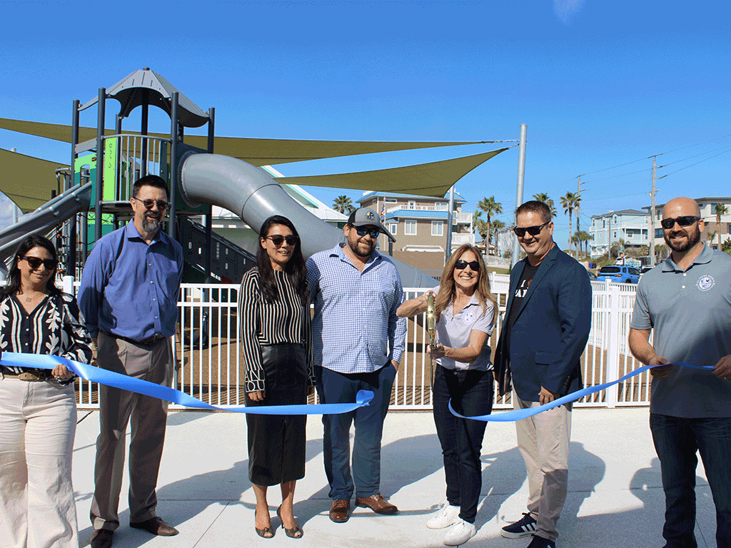 District 5 Commissioner Ann Taylor, cuts the ribbon with huge golden scissors: Parks and Recreation Assistant Director Jamie Baccari, Bhide & Hall Principal Architect Brian Sawyer, County Administrator Joy Andrews, Project Manager Chris Gatchell, Parks and Recreation Director Ryan Kane, and Project Manager Tim Connor.