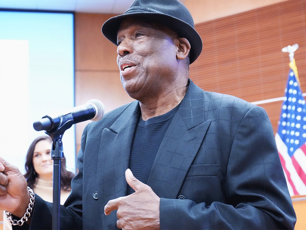 Gregory White speaking into a microphone upon acceptance of the Black History Month proclamation.