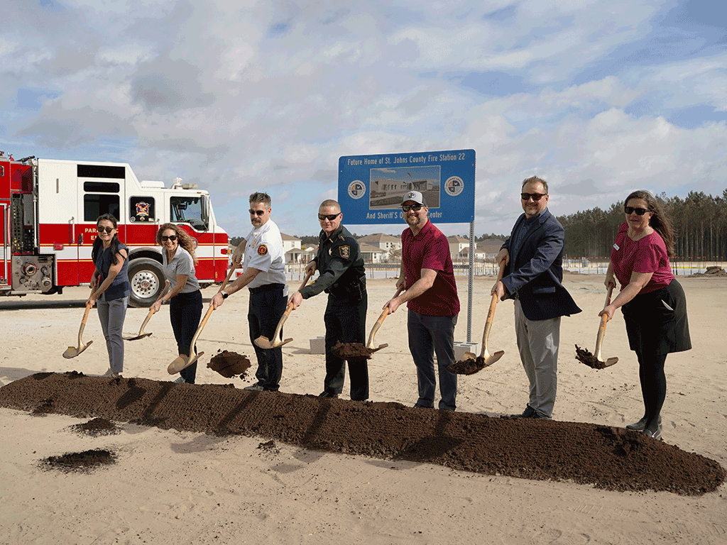 Commissioners Whitehurst and Taylor, County Administrator Joy Andrews, and others hold shovels above a plot of dirt