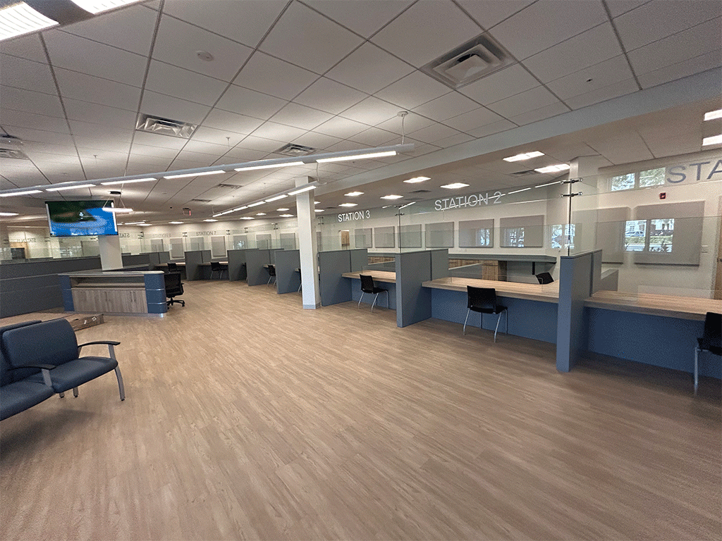 St. Johns County Permit Center interior with customer service counters and waiting area. Wood floors, blue accents, and tiled ceiling