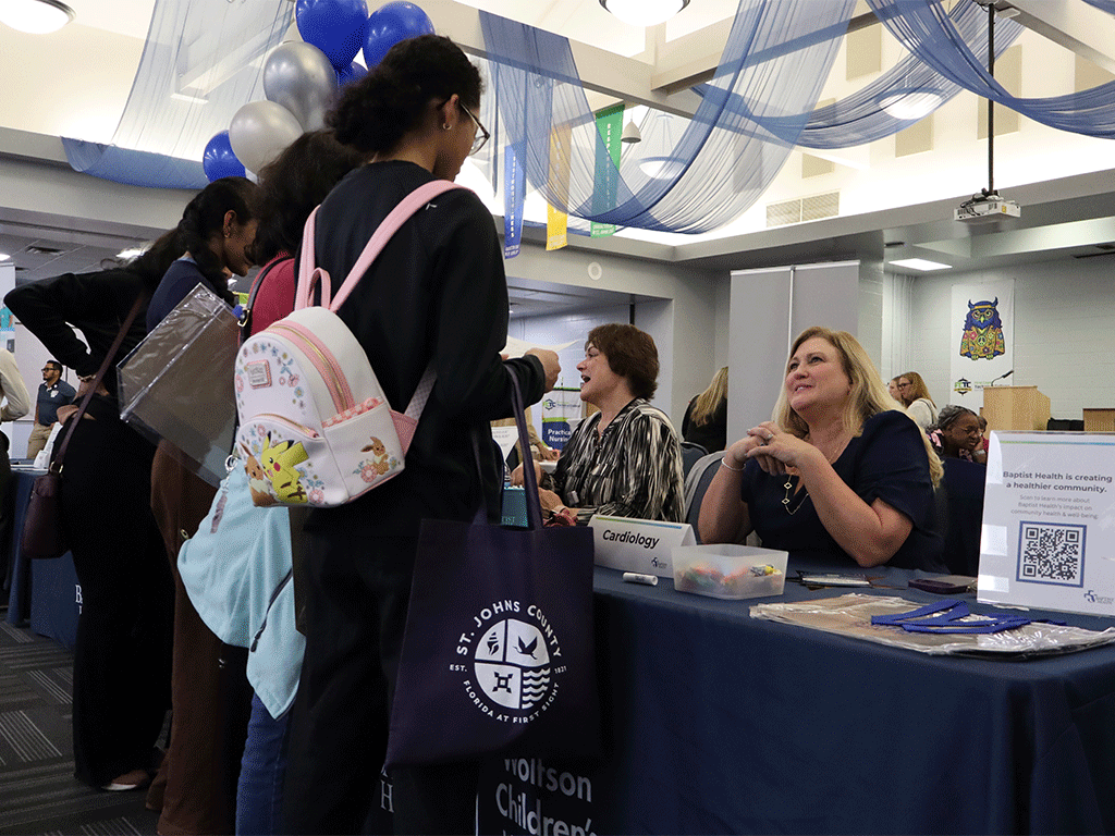 Attendee at a healthcare expo talking to a vendor