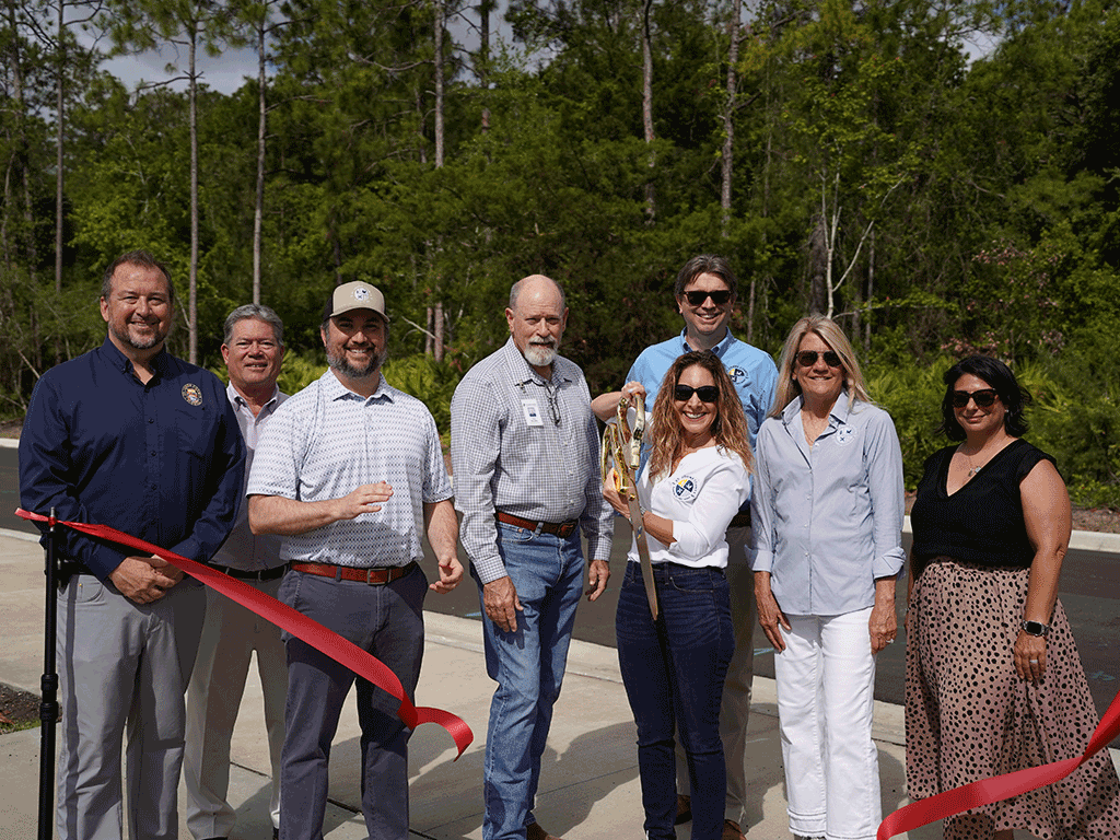 Commissioners Murphy, Taylor, Jospeh, and Whitehurst stand with others cutting a red ribbon