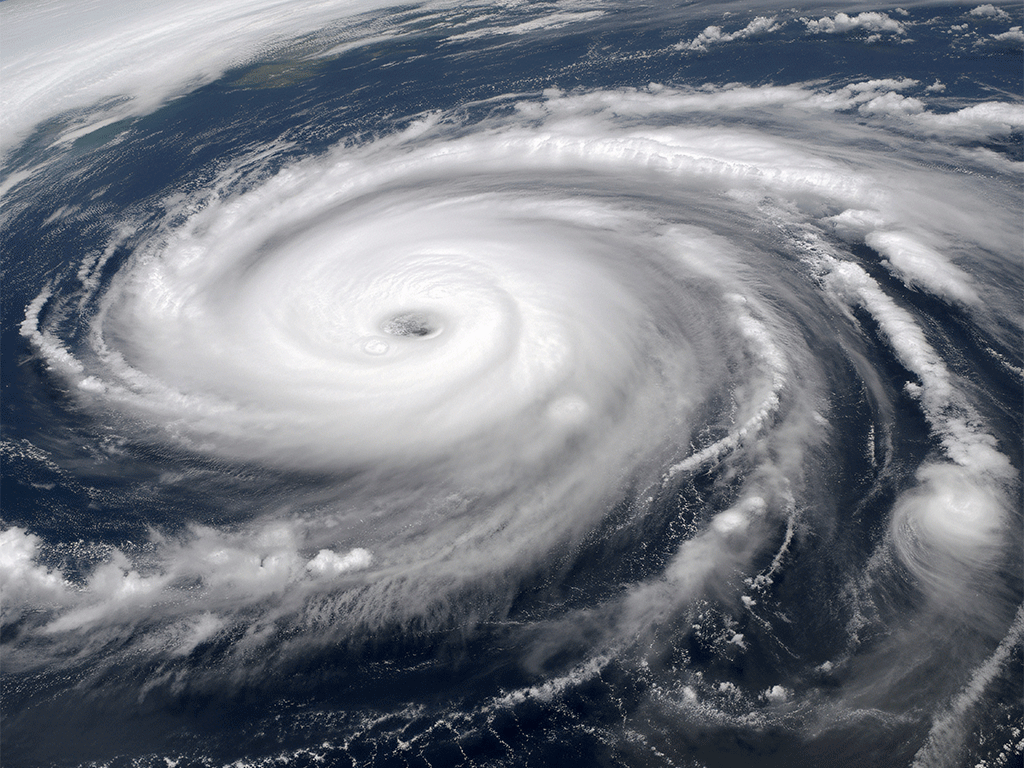 White hurricane clouds swirling over dark blue ocean