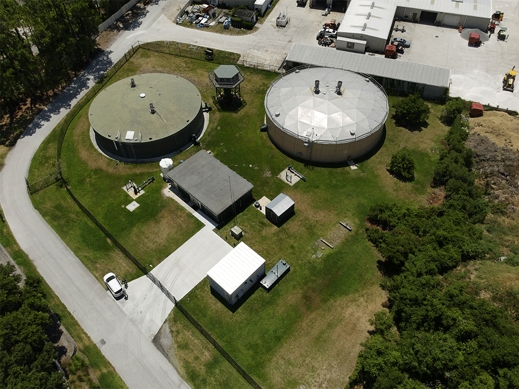 aerial view of Plantation water treatment plant with cylindrical water tanks, buildings, and greenspace.